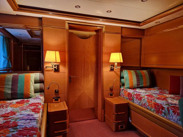  Yacht Photos Pics Luxurious Benetti Vision 145 yacht bedroom with twin beds, colorful decor, and warm lighting.
