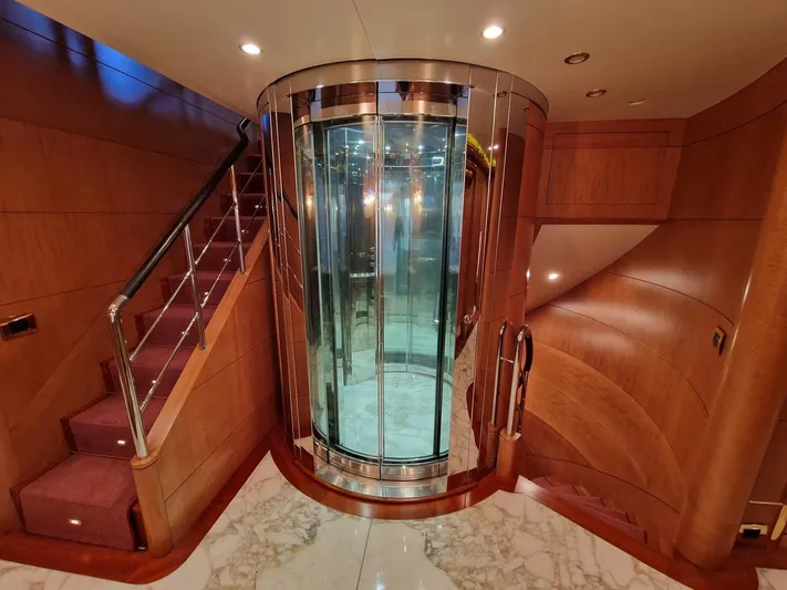  Yacht Photos Pics Luxurious interior of 2010 Benetti Vision 145 yacht with elegant glass elevator and wooden staircase.