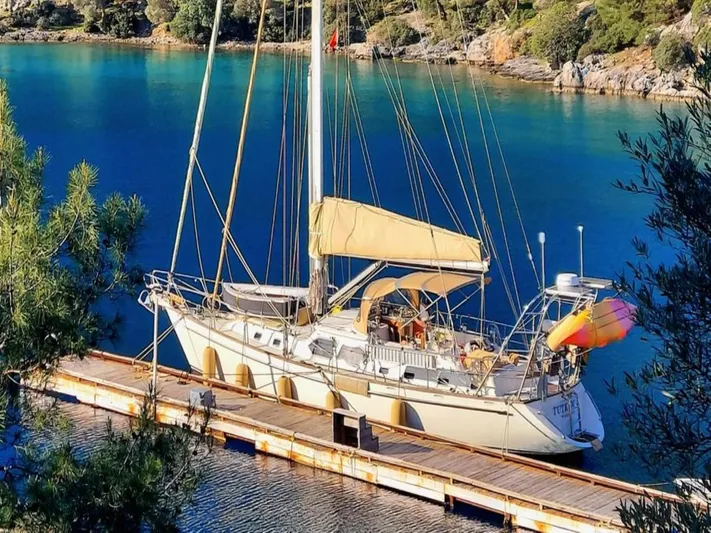 Tutkum Yacht Photos Pics Sailboat docked in serene bay, Tayana 48, 2007 model, surrounded by lush greenery.