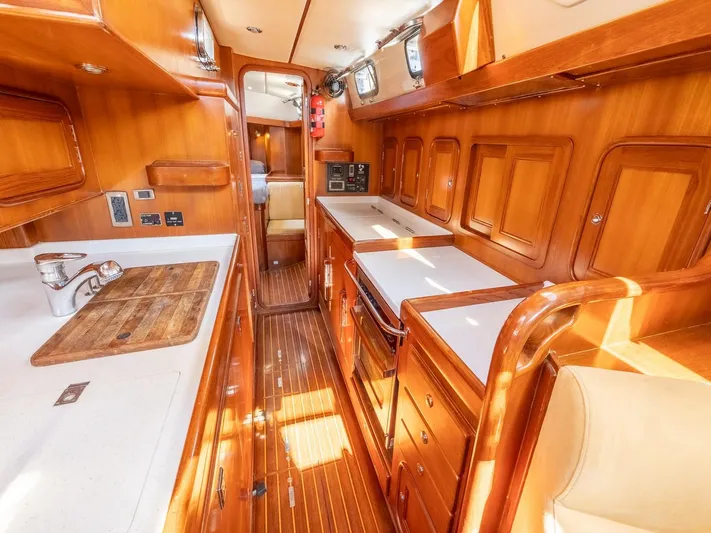 Tutkum Yacht Photos Pics Luxurious 2007 Tayana 48 yacht interior with wooden cabinetry and modern kitchen amenities.