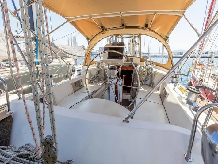 Tutkum Yacht Photos Pics 2007 Tayana 48 sailboat cockpit with wheel, canopy, and marina view.