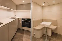 Modern kitchen and dining area in 2021 Pershing 8X yacht, featuring sleek cabinetry and cozy seating.
