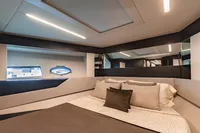 Luxurious bedroom interior of 2021 Pershing 8X yacht with modern design and elegant bedding.