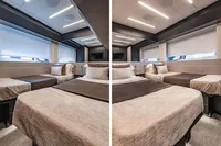 Luxurious bedroom interior of 2021 Pershing 8X yacht with modern design and cozy bedding.