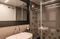 Modern bathroom in 2021 Pershing 8X yacht with sleek sink and glass shower.