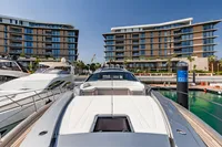 Luxury Pershing 8X yacht docked at marina with modern buildings in background, 2021 model.