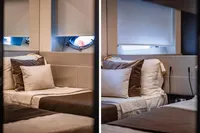 Luxurious interior of 2021 Pershing 8X yacht with elegant bedding and porthole windows.