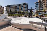 Luxurious 2021 Pershing 8X yacht docked near modern waterfront buildings.