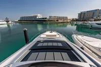 2021 Pershing 8X yacht docked in a marina with modern buildings in the background.
