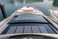 2021 Pershing 8X yacht docked in a marina with modern buildings in the background.
