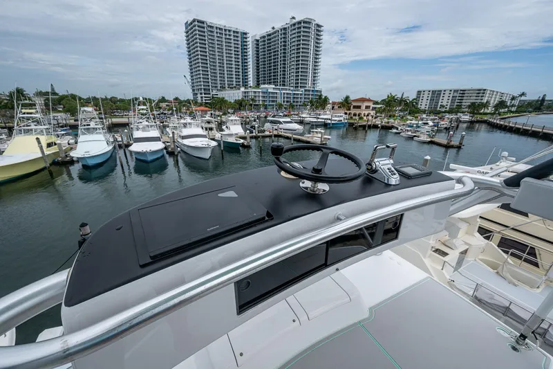 Ebitda Yacht Photos Pics 2009 Viking 60 Convertible yacht helm overlooking marina with docked boats and high-rise buildings.
