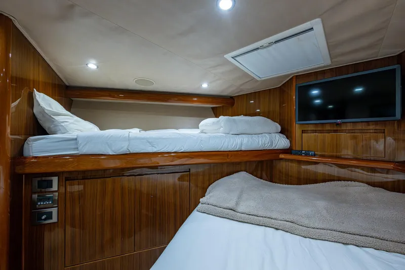 Ebitda Yacht Photos Pics Luxurious cabin interior of 2009 Viking 60 Convertible yacht with bunk beds and TV.