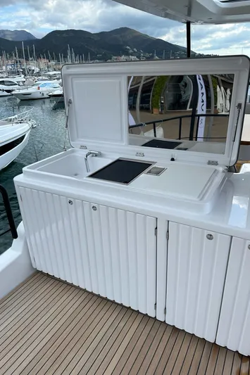  Yacht Photos Pics 2024 Azimut Magellano 60 yacht with outdoor kitchenette, docked in a scenic marina.