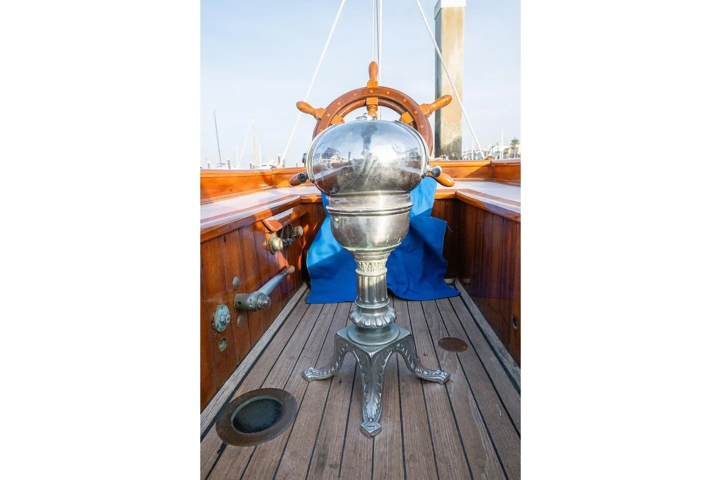 1938 Philip Rhodes Cutter boat helm with polished metal binnacle and wooden deck.
