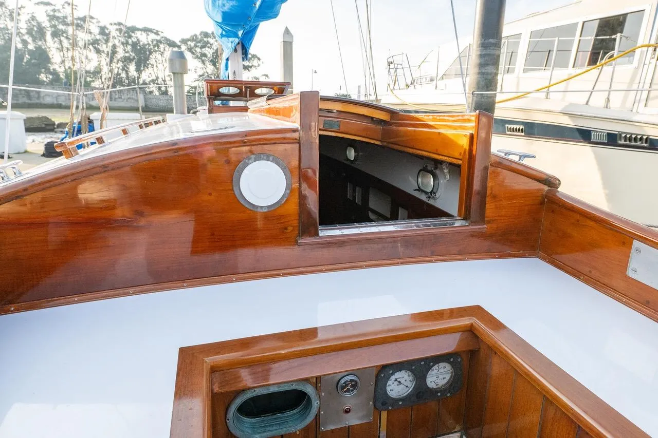 1938 Philip Rhodes Cutter sailboat with polished wood interior and nautical instruments.