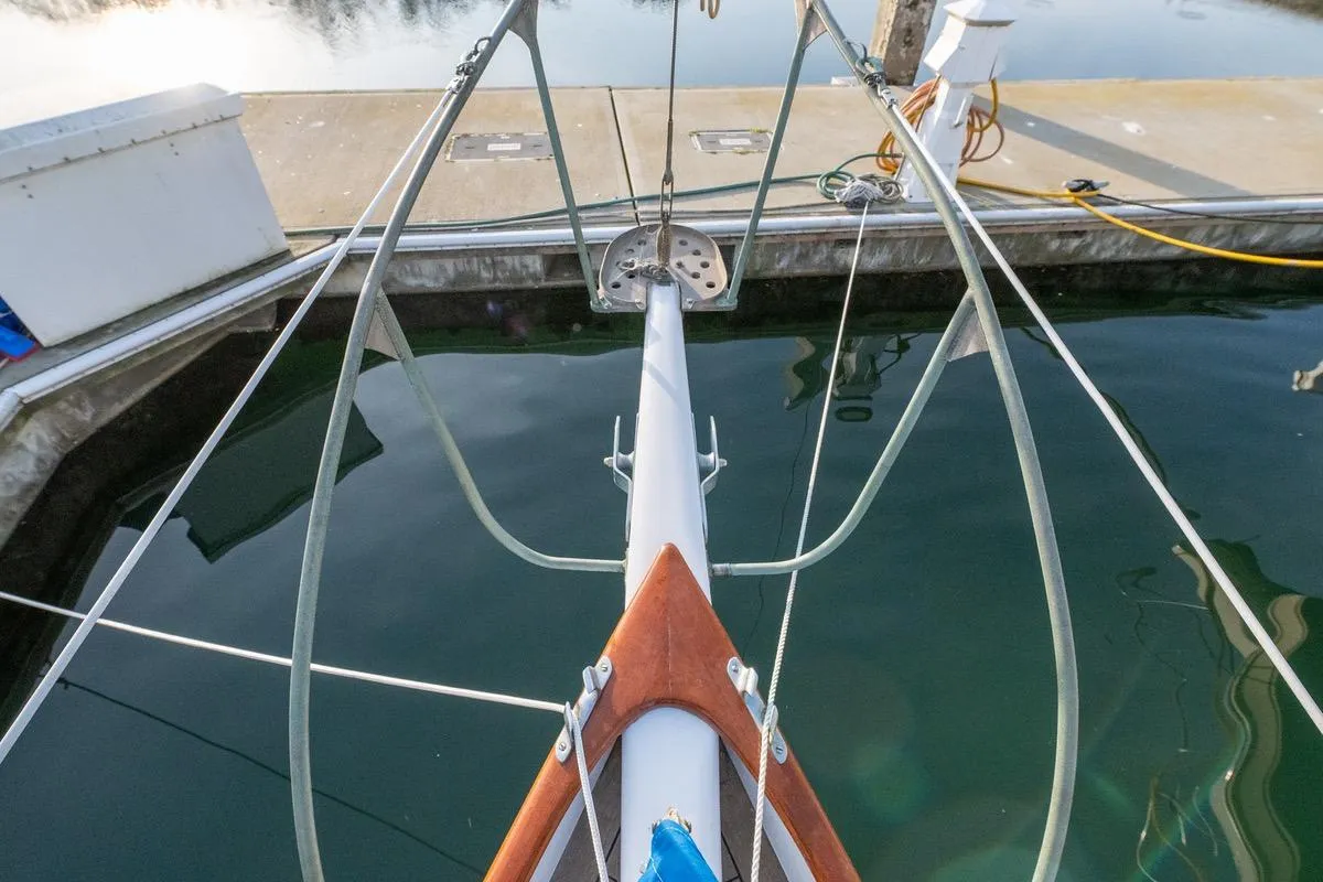 Bow view of a 1938 Philip Rhodes Cutter sailboat docked at a marina.