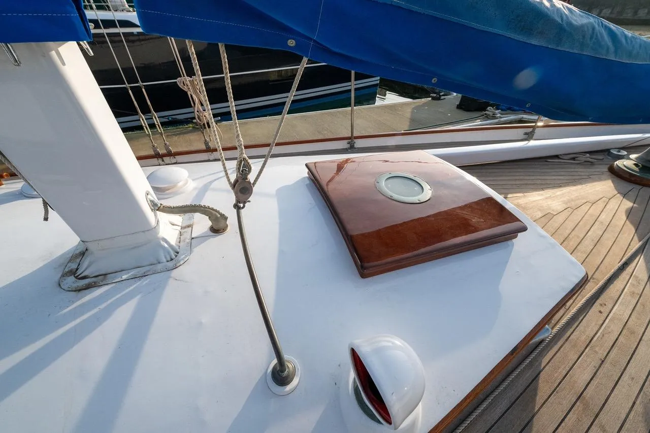 1938 Philip Rhodes Cutter deck with wooden hatch and blue sail cover.