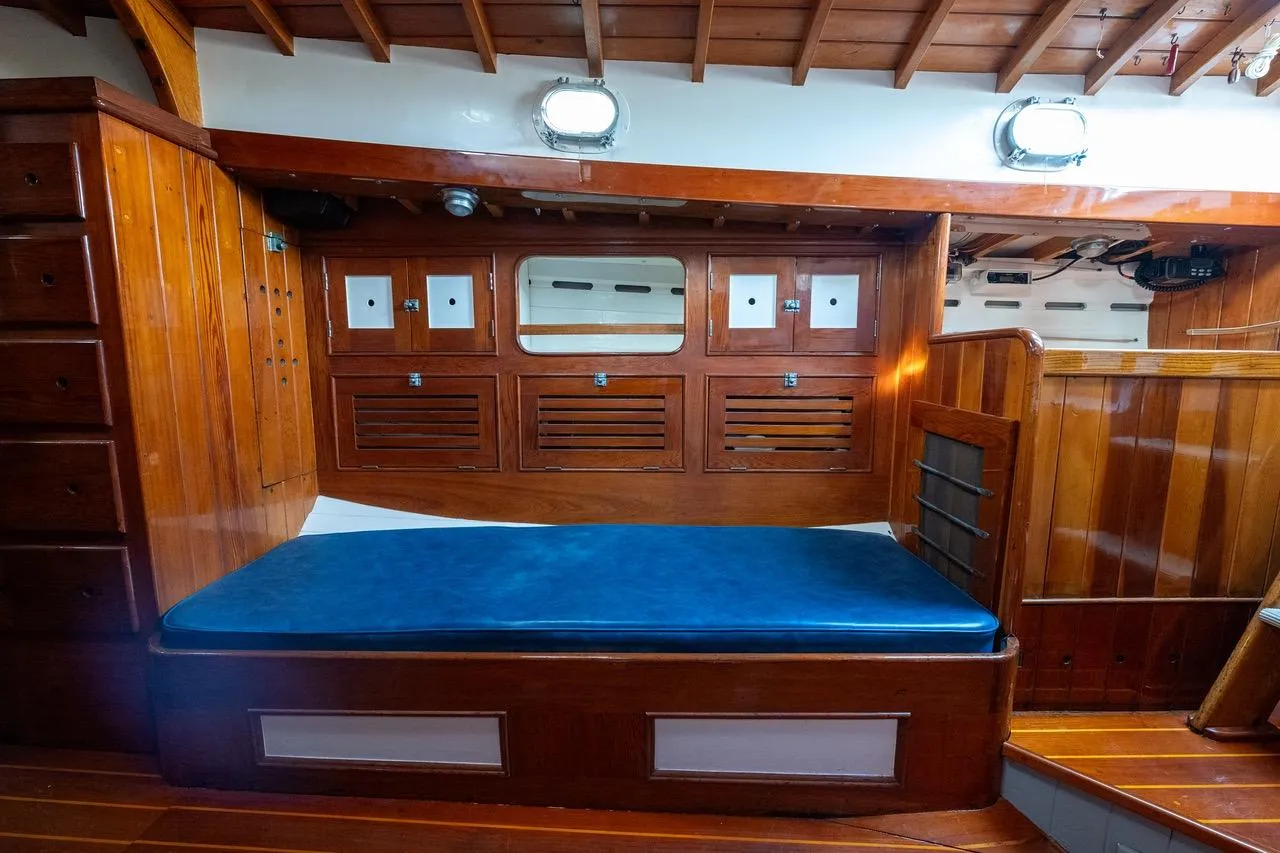 1938 Philip Rhodes Cutter interior with wooden cabinetry and blue cushioned seating.