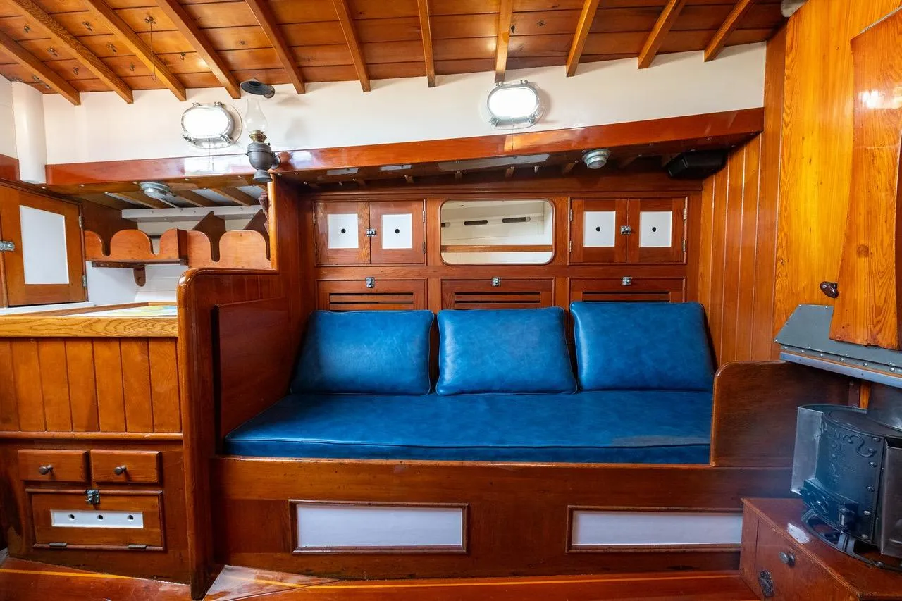 Interior of a 1938 Philip Rhodes Cutter with wooden paneling and blue seating.