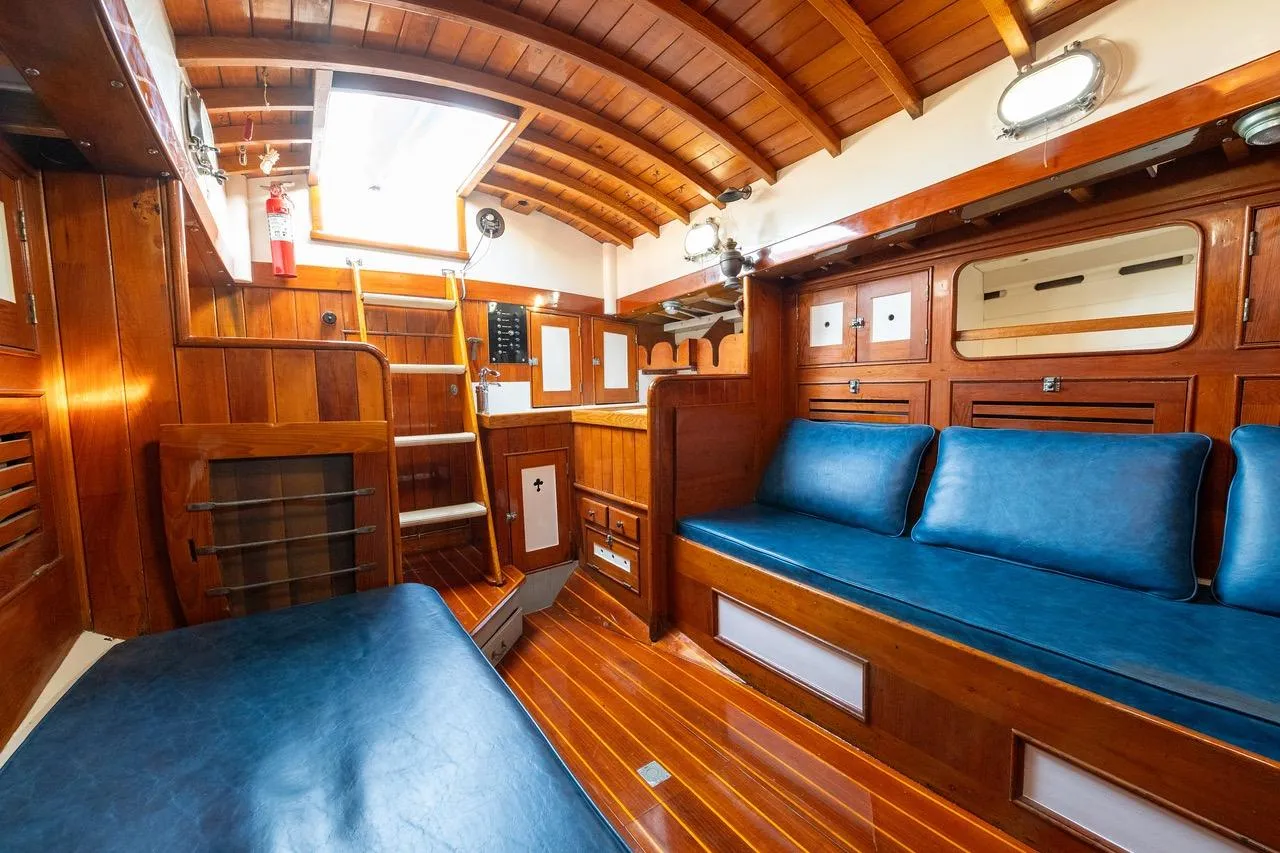 Interior of a 1938 Philip Rhodes Cutter, featuring wooden paneling and blue seating.