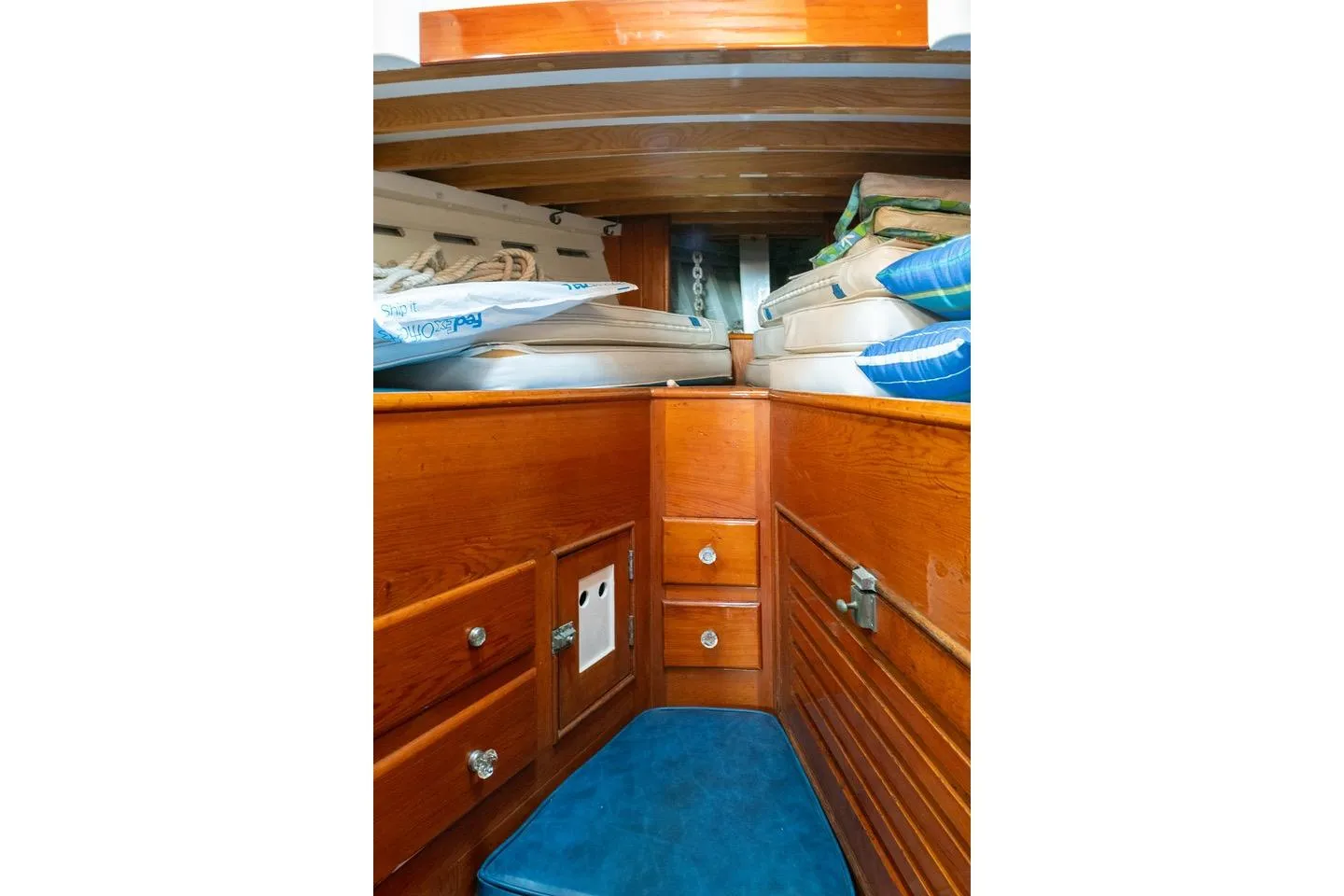 Interior of 1938 Philip Rhodes Cutter, featuring wooden cabinetry and blue cushions.