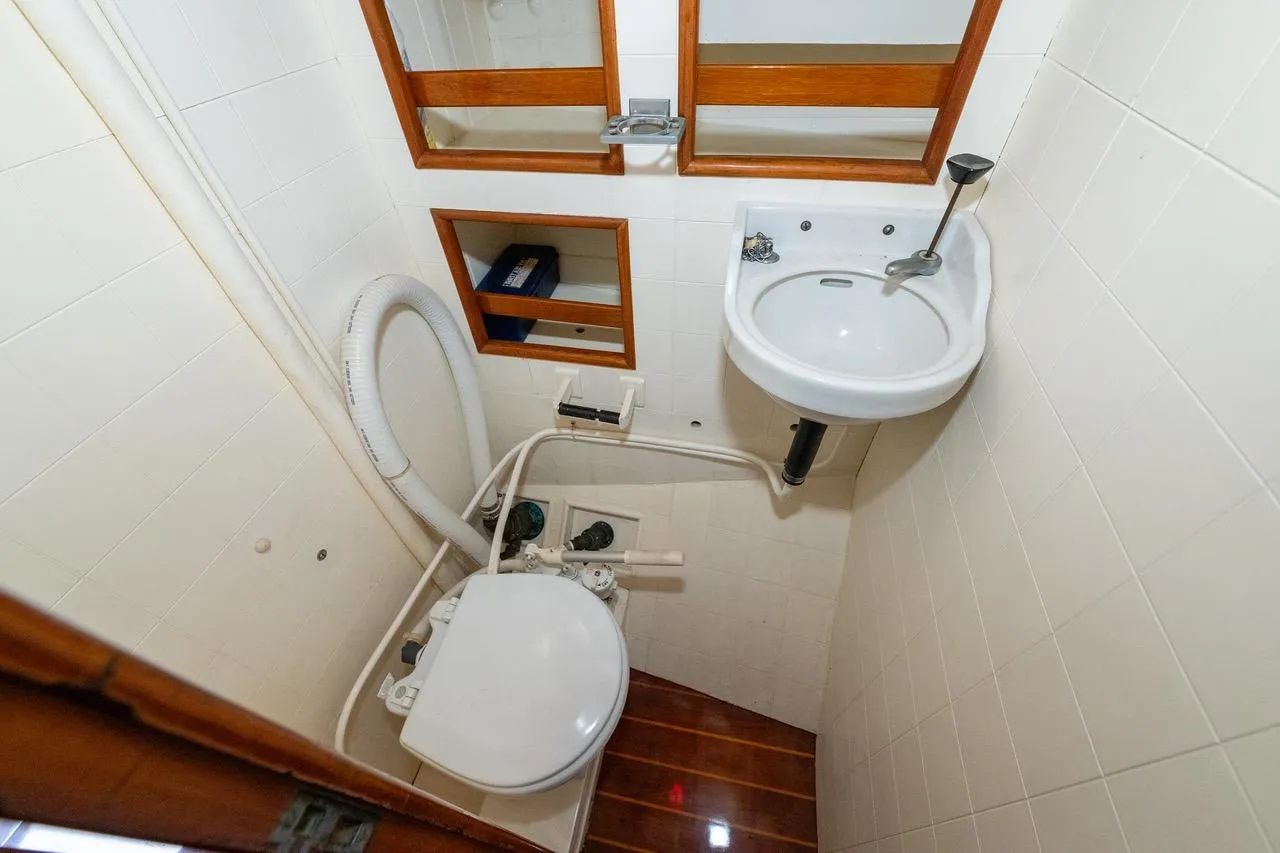 Compact bathroom in 1938 Philip Rhodes Cutter boat with sink and toilet.