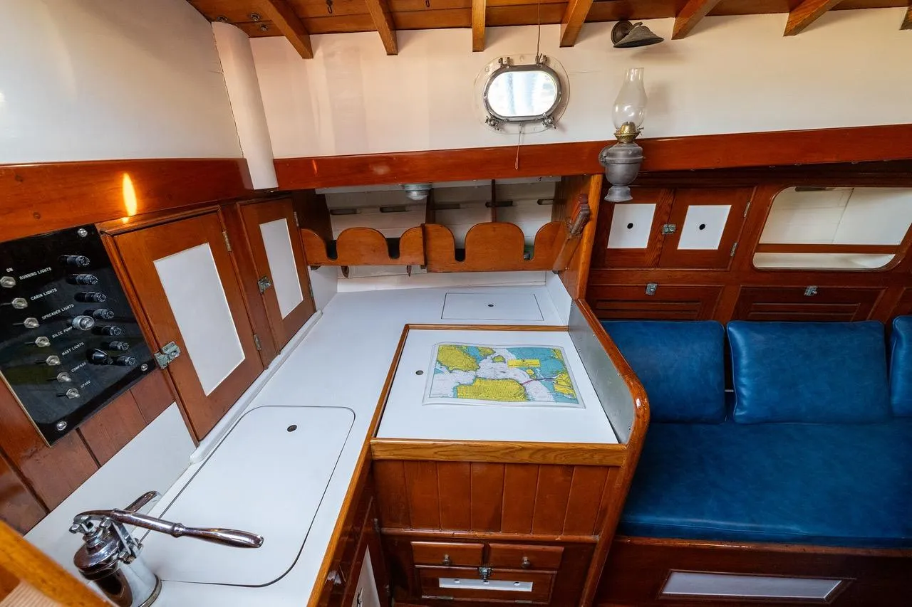 Interior of a 1938 Philip Rhodes Cutter, featuring a classic wooden design and nautical map.