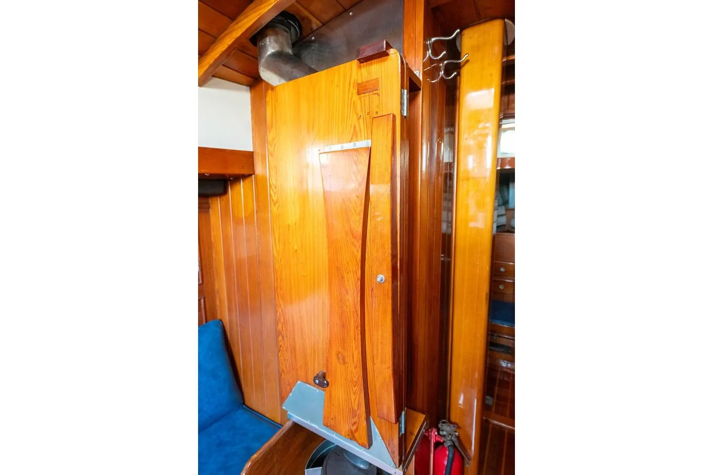 Interior of 1938 Philip Rhodes Cutter, featuring polished wooden paneling and blue seating.