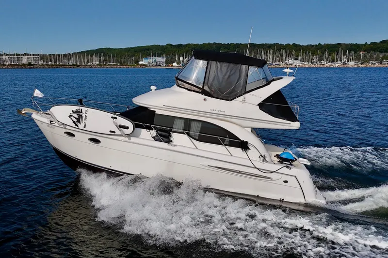  Yacht Photos Pics 2003 Meridian 341 Sedan cruising on blue water near marina.