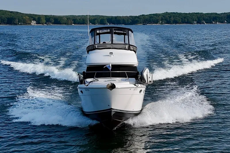  Yacht Photos Pics 2003 Meridian 341 Sedan cruising on a lake with forested shoreline.