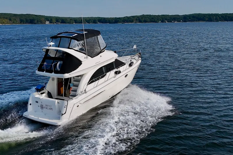  Yacht Photos Pics 2003 Meridian 341 Sedan cruising on a serene lake with lush green shoreline.