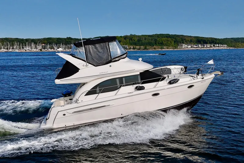  Yacht Photos Pics 2003 Meridian 341 Sedan cruising on a scenic lake with forested shoreline.