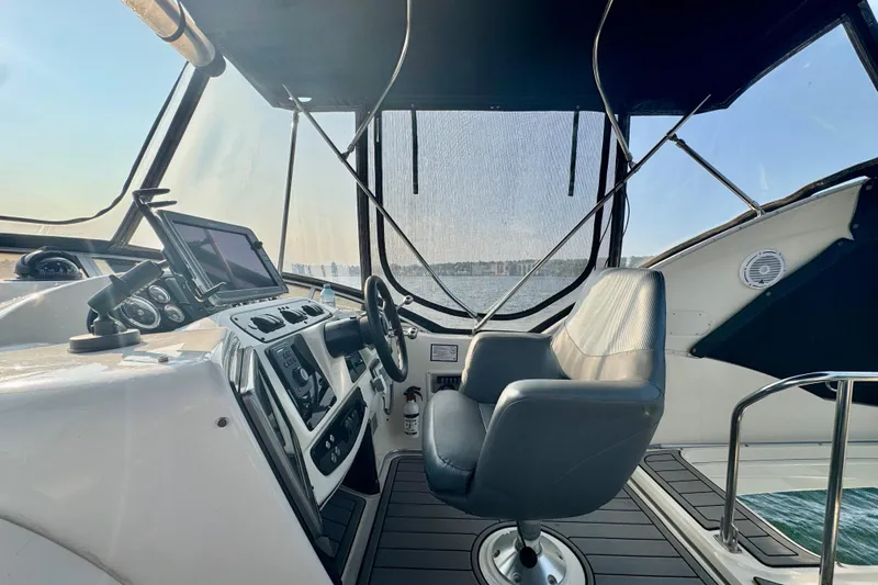  Yacht Photos Pics 2003 Meridian 341 Sedan helm with steering wheel, navigation equipment, and captain's chair.