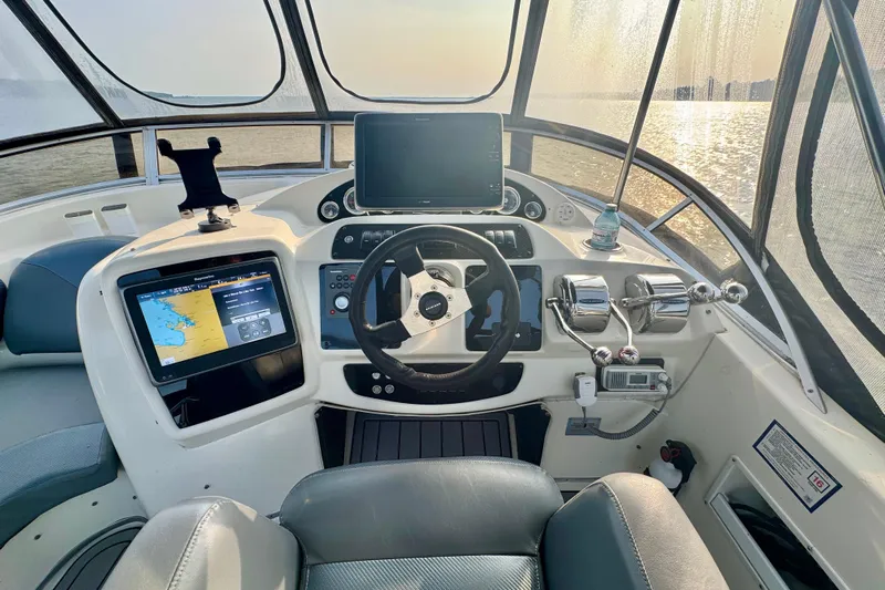  Yacht Photos Pics 2003 Meridian 341 Sedan helm with navigation screens and controls, overlooking a sunny seascape.