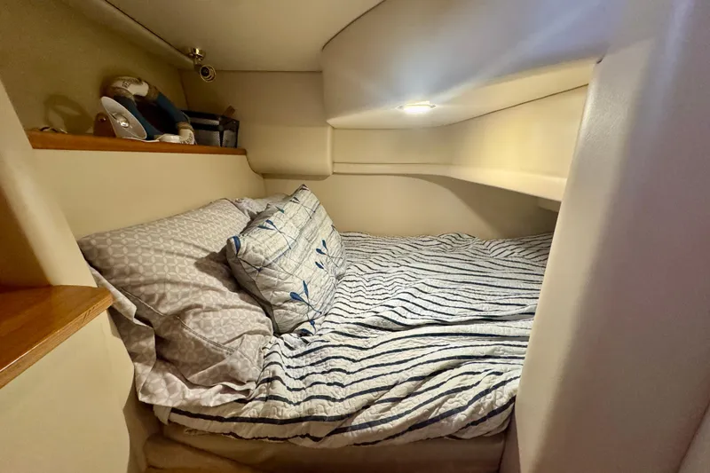  Yacht Photos Pics Cozy cabin interior of 2003 Meridian 341 Sedan with striped bedding and soft lighting.