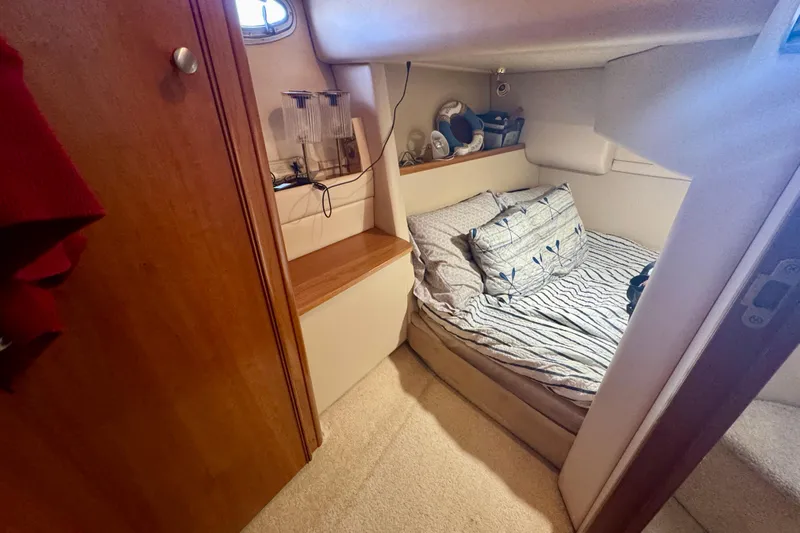  Yacht Photos Pics Cozy cabin interior of 2003 Meridian 341 Sedan with striped bedding and wooden accents.
