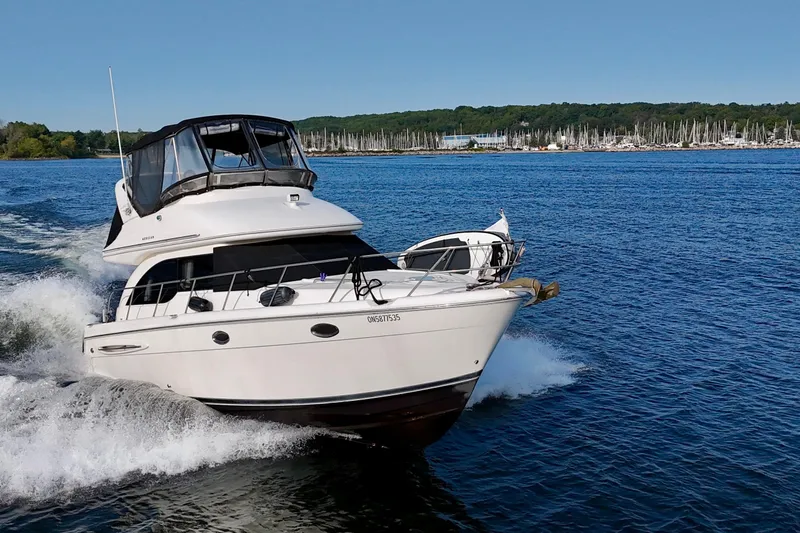  Yacht Photos Pics 2003 Meridian 341 Sedan cruising on a lake with marina in the background.
