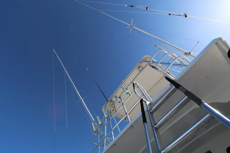  Yacht Photos Pics 2006 Island Hopper Sportfisher boat with fishing rods against clear blue sky.