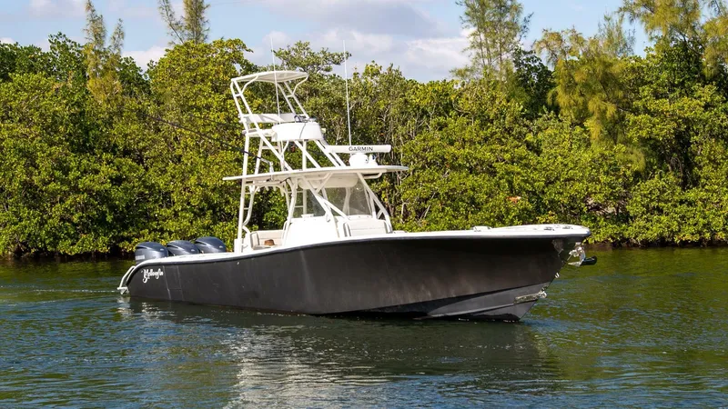 Evil Tequila Yacht Photos Pics 2015 Yellowfin 39 Offshore boat on water, surrounded by lush greenery.