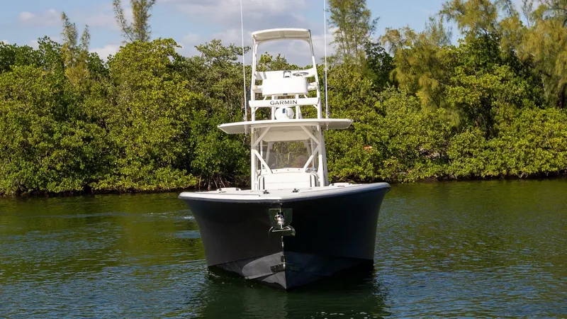 Evil Tequila Yacht Photos Pics 2015 Yellowfin 39 Offshore boat on calm water, surrounded by lush greenery.
