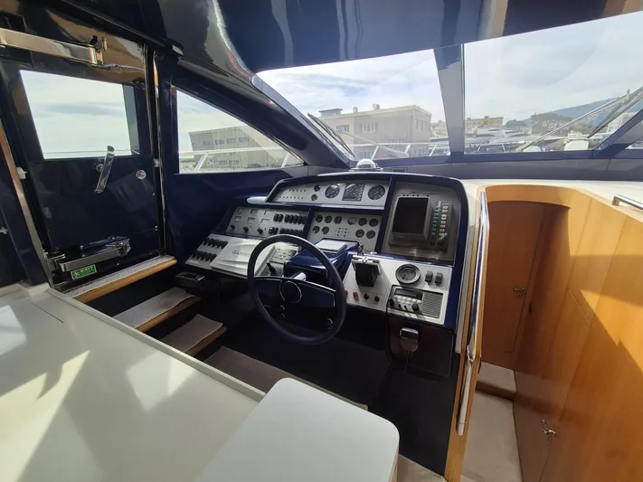  Yacht Photos Pics Cockpit of a 1998 Riva Dolce Vita yacht with steering wheel and control panel.