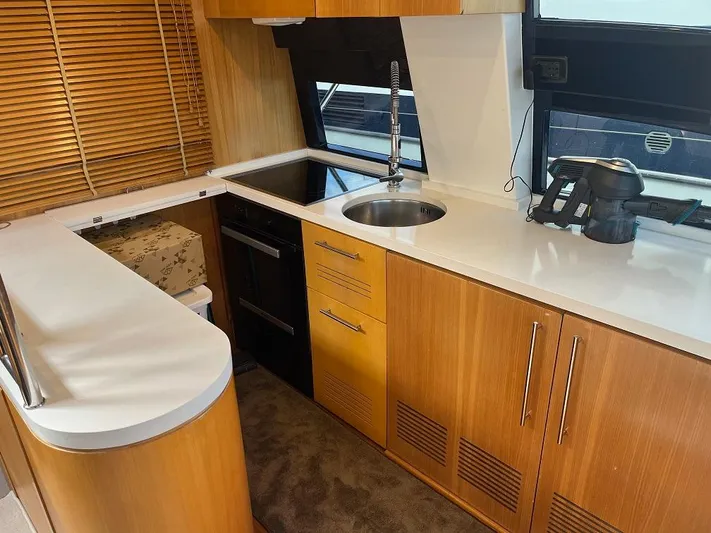  Yacht Photos Pics Kitchen area of a 1998 Riva Dolce Vita yacht with wooden cabinets and modern appliances.