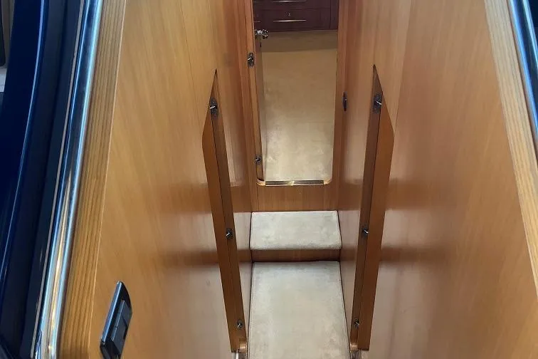  Yacht Photos Pics Interior view of 1998 Riva Dolce Vita yacht with wooden paneling and carpeted steps.