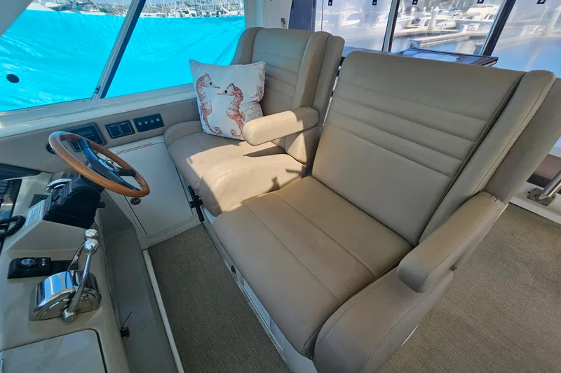 Reflections Yacht Photos Pics 2005 Sea Ray 390 Motor Yacht helm with beige seating and seahorse pillow.