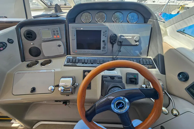 Reflections Yacht Photos Pics 2005 Sea Ray 390 Motor Yacht helm with navigation instruments and wooden steering wheel.