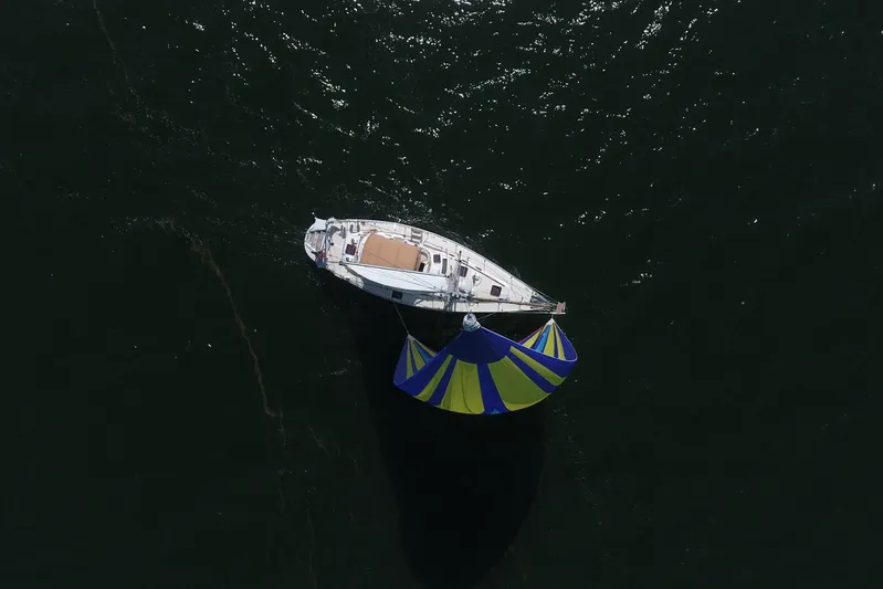 Legacy Yacht Photos Pics Aerial view of 2012 Hylas 49CC sailboat with colorful spinnaker on dark water.