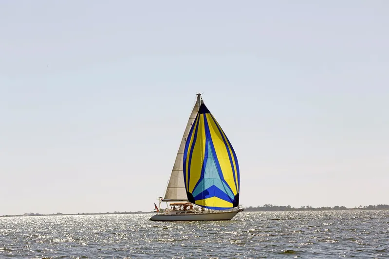 Legacy Yacht Photos Pics Sailboat Hylas 49CC 2012 with colorful spinnaker on shimmering water.