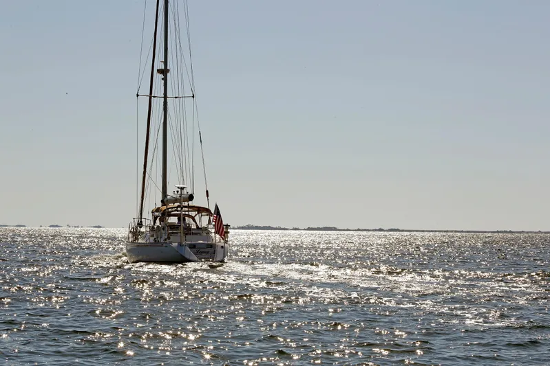 Legacy Yacht Photos Pics Sailing yacht Hylas 49CC (2012) on shimmering ocean waters under clear sky.