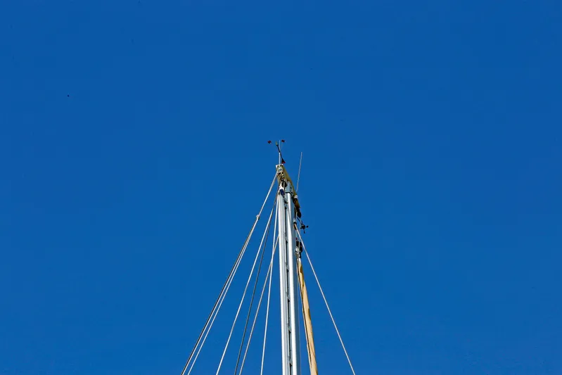 Legacy Yacht Photos Pics Mast of 2012 Hylas 49CC sailboat against clear blue sky.