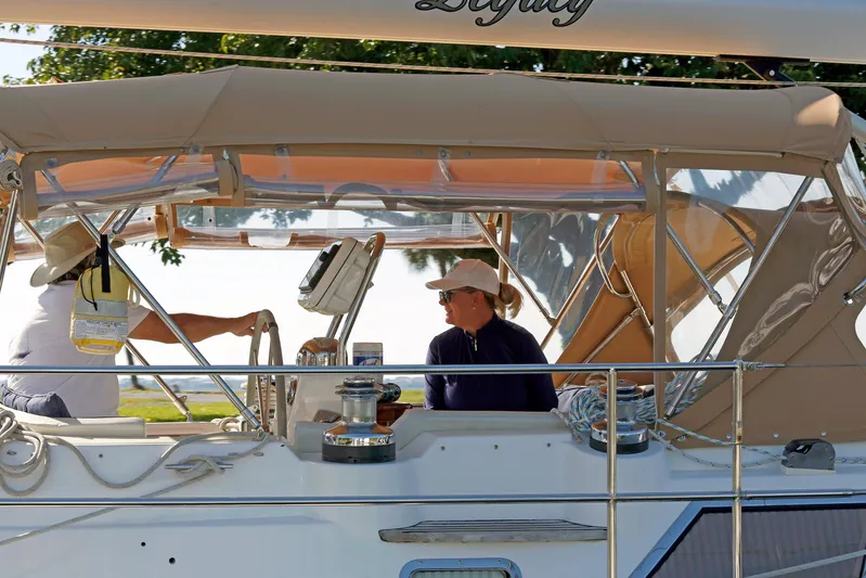 Legacy Yacht Photos Pics People relaxing on a 2012 Hylas 49CC sailboat under a canopy.